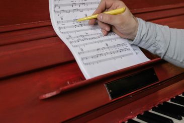 pexels-a-darmel-7322031 Pianista componiendo partitura mientras toca el piano